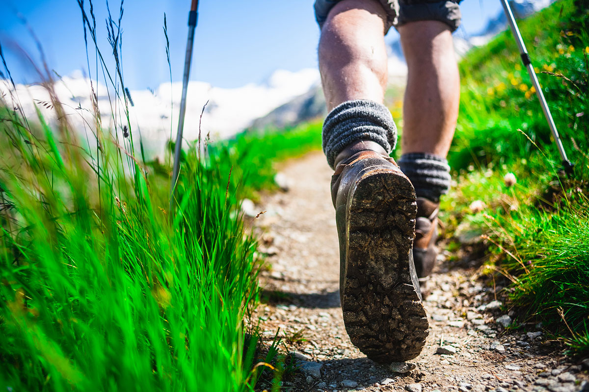 Person walking along a hiking trail in New England trying to prevent tick bites